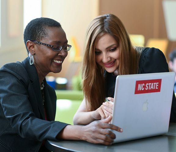 two women looking at a laptop computer